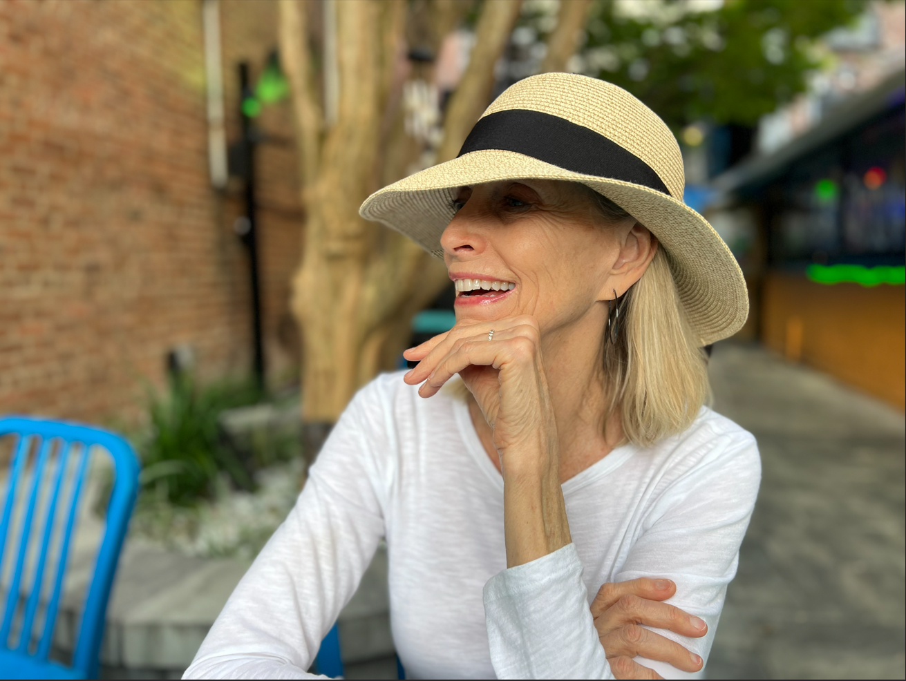 Dianne, board-certified art therapist, smiling outdoors in a straw sun hat